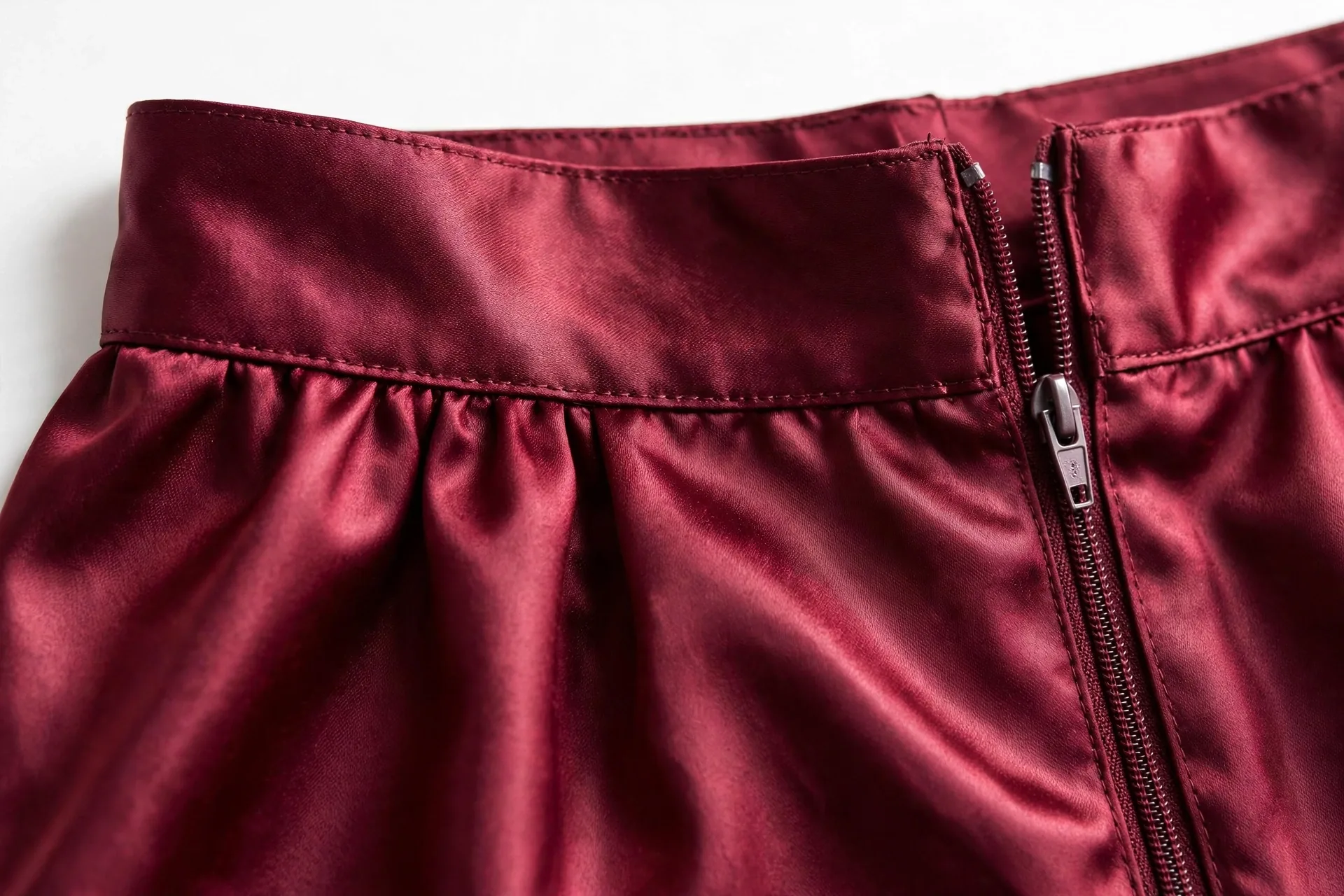 Burgundy satin skirt waistband with flat stitching detail