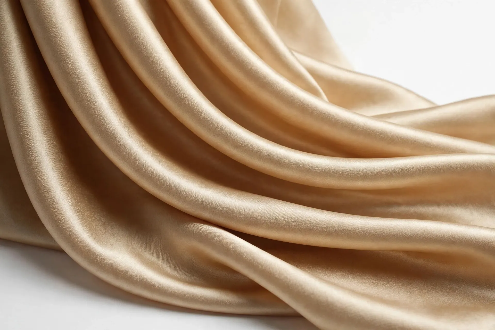 Champagne satin folds with sharp specular highlights along the curves