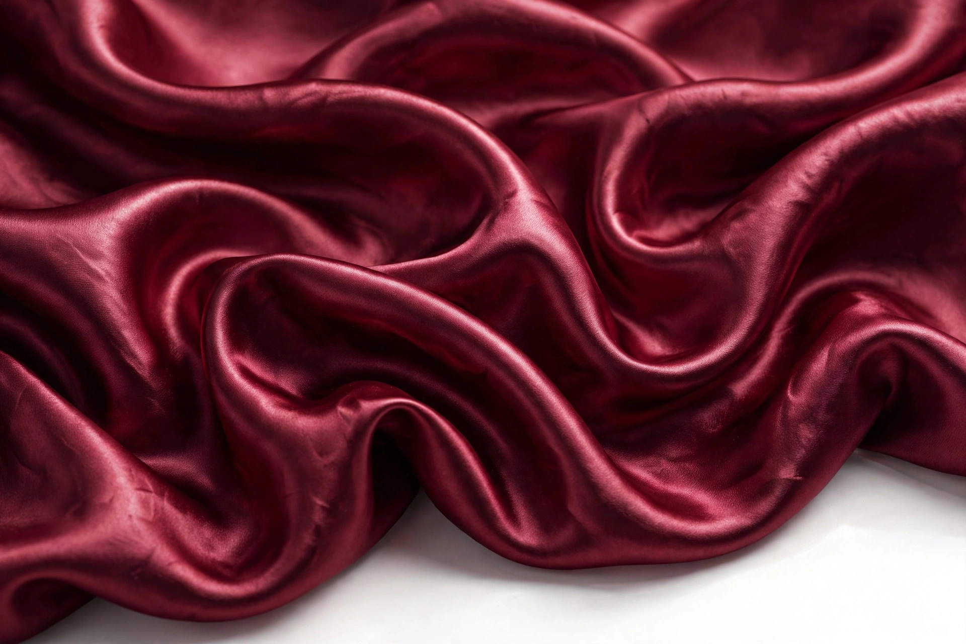 Close-up of burgundy charmeuse satin with liquid folds