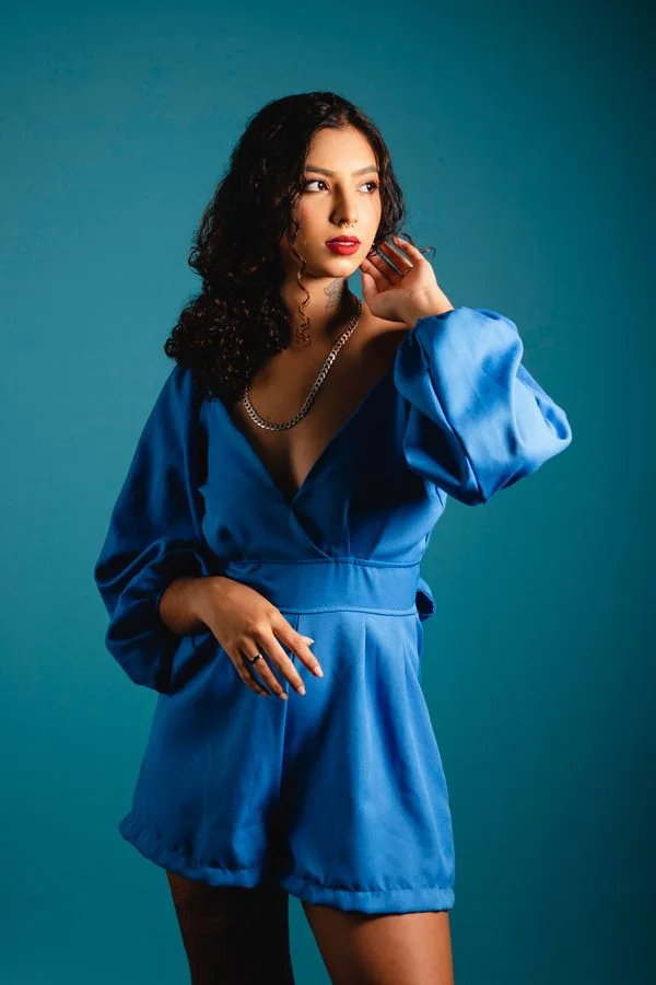 Woman wearing a royal blue satin top in the evening